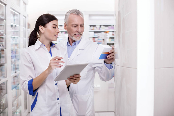 Mature male doctor assisting pharmacist - Photo, Image
