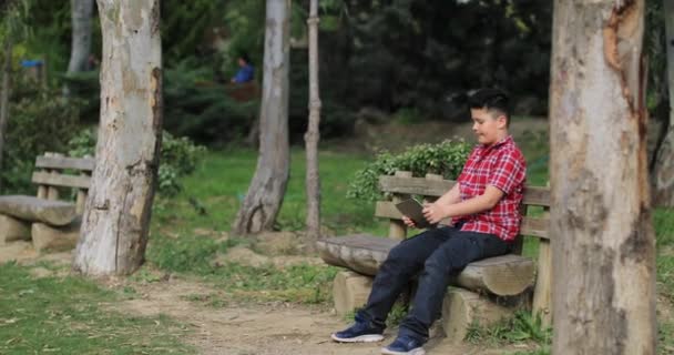 Sorridente giovane ragazzo fare foto selfie al parco verde primaverile
 - Filmati, video