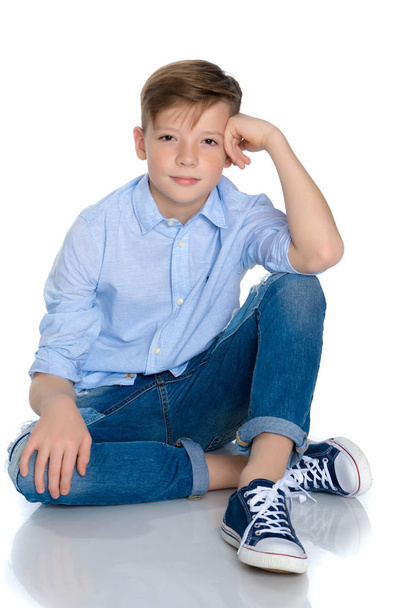 Fashionable boy teen sitting on the floor. - Foto, imagen