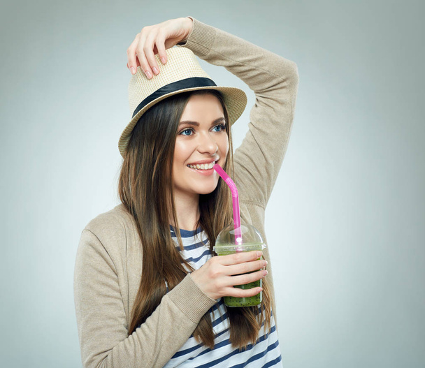 smiling woman in hat holding glass with green smoothie  - Photo, image