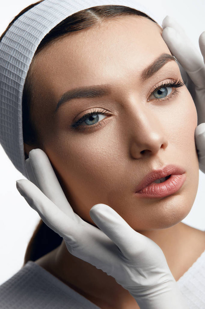 Plastic Surgery. Hands Touching Beautiful Woman Face - Foto, Imagen