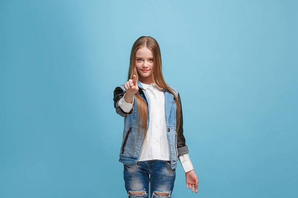 The happy teen girl pointing to you, half length closeup portrait on blue background. - Фото, зображення