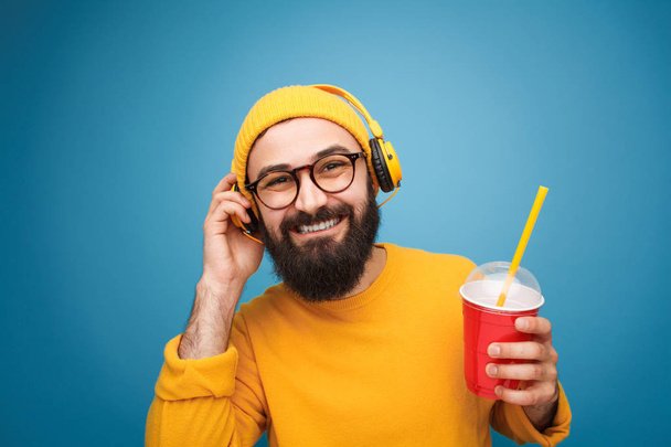 Content man with headphones and drink - Zdjęcie, obraz