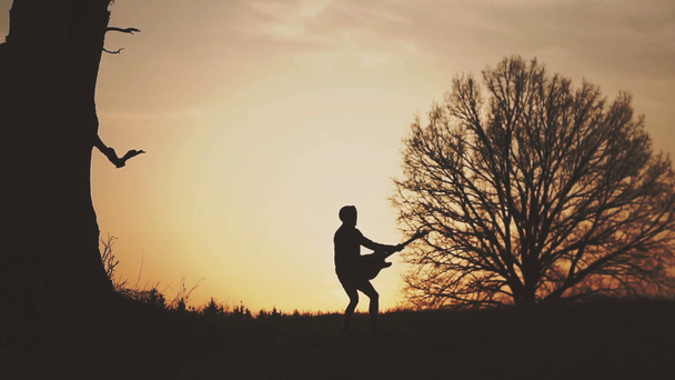 Sziluettjét naplemente lassított gitárosa - Felvétel, videó