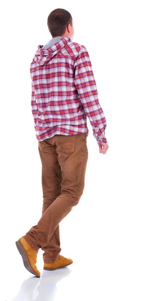 Back view of walking teenager in plaid shirt with hood - Foto, afbeelding