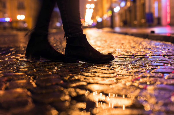 Mujer en zapatos negros caminando por la calle de la ciudad en la noche
 - Foto, Imagen