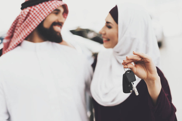Arabic couple at car dealership, man presenting new car his wife - Foto, Imagen