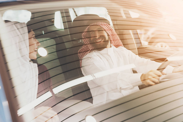 Arabic couple at car dealership, man and woman choosing new car - Фото, изображение