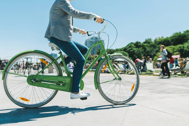 A stylish man rides a beautiful city park bike ride. Walk on a bike. Active rest. Walking bicycle - Photo, Image