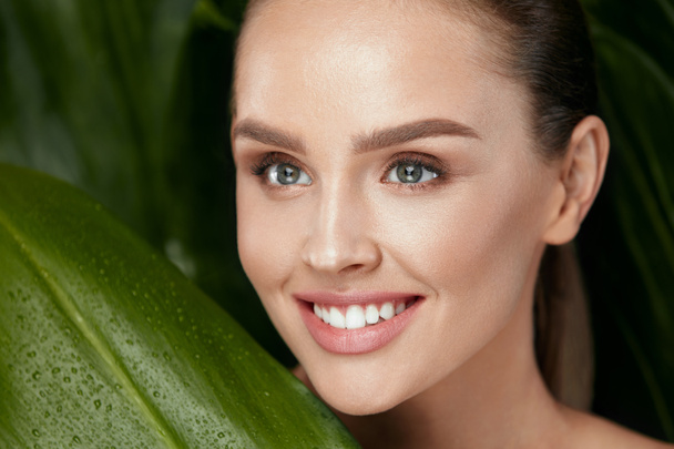 Natural Cosmetics. Beautiful Woman Face With Green Plant - Photo, Image