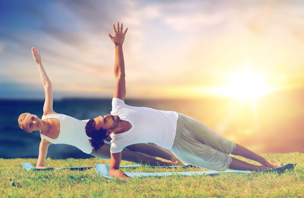 couple doing yoga and side plank outdoors - Photo, Image