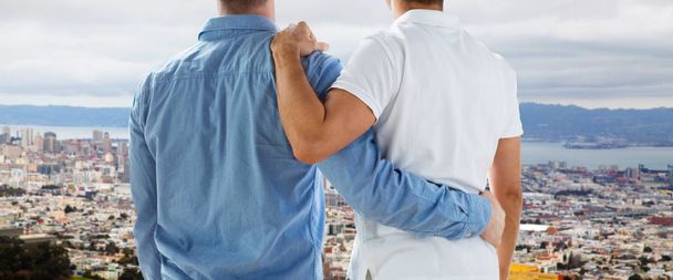 close up of gay couple hugging over san francisco - Foto, afbeelding