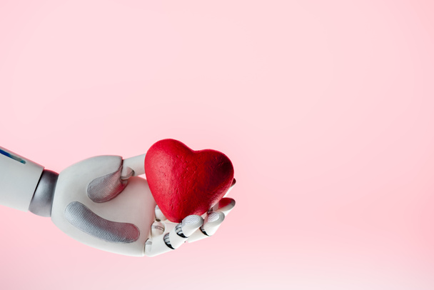 mão robô segurando coração vermelho isolado em rosa
 - Foto, Imagem