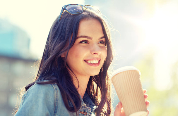 happy young woman drinking coffee on city street - Foto, Imagen