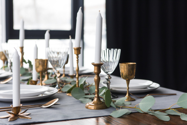 rusztikus asztal elrendezése, eukaliptusz, evőeszköz, gyertyák, gyertyatartók, és üres lemezeket - Fotó, kép