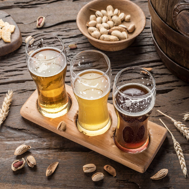 Glasses of beer and snacks on the wooden table. - Foto, Bild