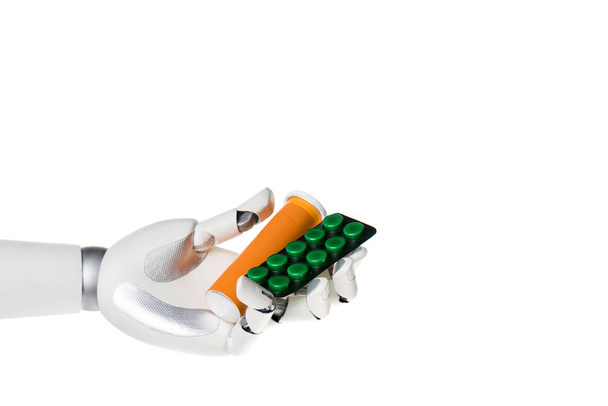 robot hand holding bottle and blister with pills isolated on white - Fotó, kép