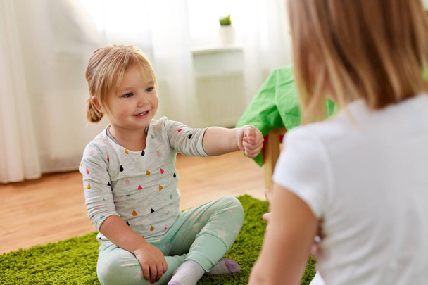 girls playing rock-paper-scissors game at home - Photo, Image
