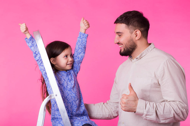 Батько зі своєю дочкою показує великий палець вгору
 - Фото, зображення