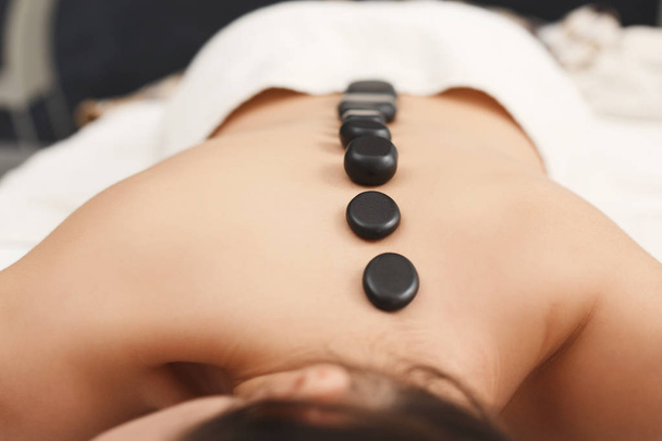 Mujer recibiendo masajes de piedras calientes en el salón de spa
 - Foto, Imagen