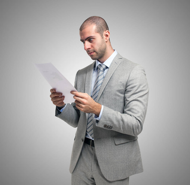 Worried businessman reading a document - 写真・画像