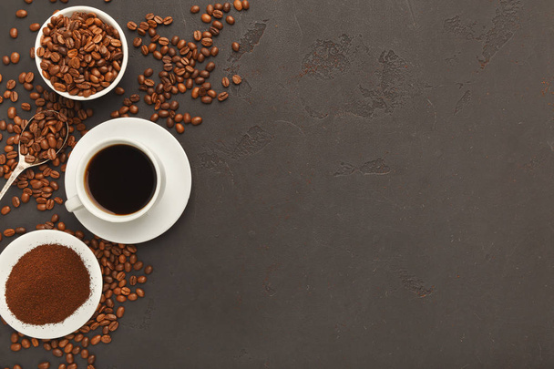 Cup of black coffee and scattered beans on gray background - Photo, Image