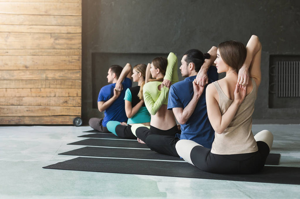 Jovens mulheres e homens na aula de ioga, relaxe a postura de meditação
 - Foto, Imagem