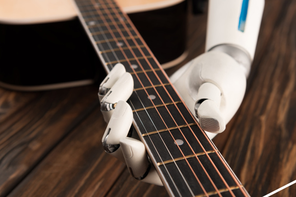 cropped shot of robot playing guitar over wooden surface - Photo, Image