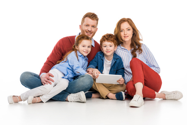 happy redhead family using digital tablet and smiling at camera isolated on white - Фото, изображение
