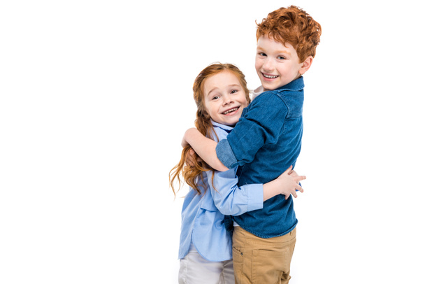 красивый рыжий брат и сестра обнимаются и улыбаются перед камерой, изолированной на белом
 - Фото, изображение