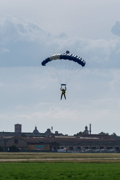 Skoczka spadochronowego z niebieski spadochron blisko ziemi, przygotowanie do lądowania - Zdjęcie, obraz