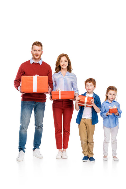 happy red haired family holding gifts and smiling at camera isolated on white  - Fotoğraf, Görsel