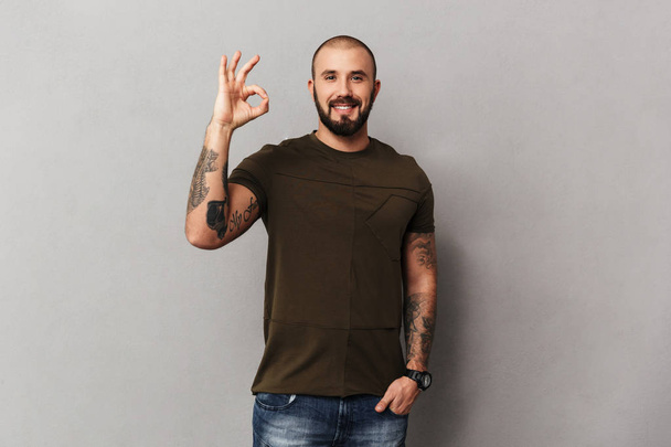 Image of unshaved muscular guy with tattoos on hands posing at c - Fotoğraf, Görsel