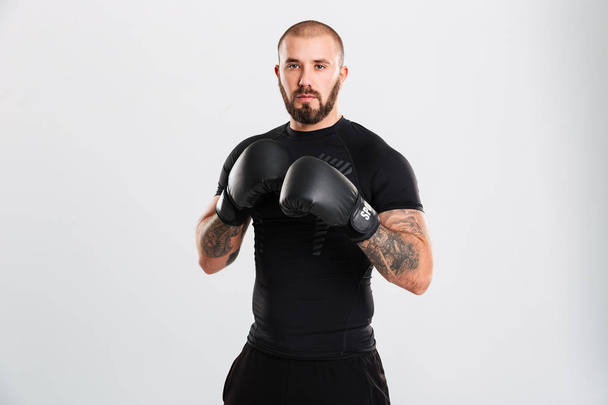 Portrait of strong-willed sportsman in boxing gloves looking on  - Photo, image