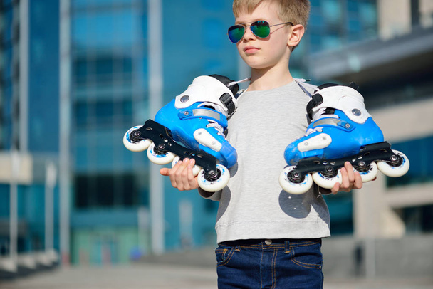 Young beautiful boy with roller skates in his hands - Photo, Image