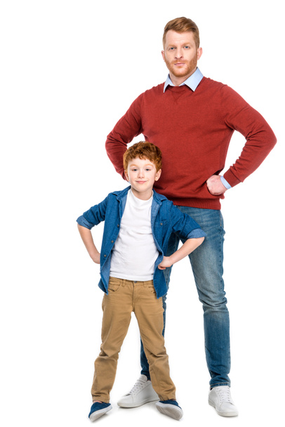 redhead father and son standing with hands on waist and looking at camera isolated on white - Foto, Imagem