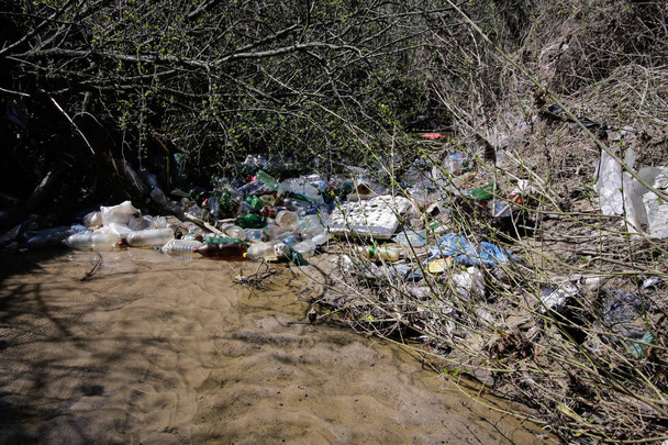 Heavy polluted water stream with domestic garbage - Photo, Image