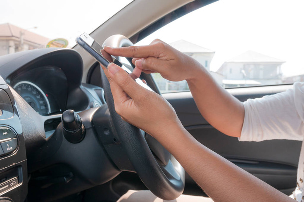 Mãos de mulher usando telefone inteligente móvel no carro para celular te
 - Foto, Imagem