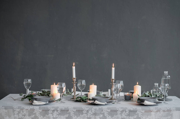 Table setting. Candles, plates and glasses - 写真・画像