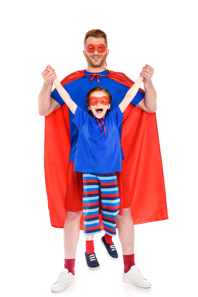 feliz padre e hija en trajes de superhéroe divertirse juntos y sonriendo a la cámara aislada en blanco
 - Foto, imagen