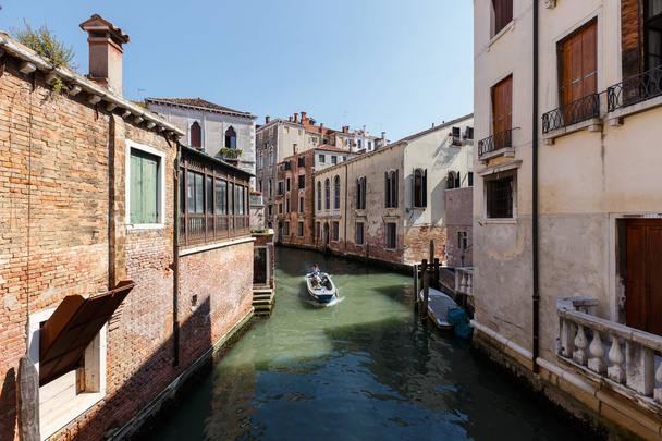 Typical view of boat with passengers on the canal of Venice. Sunny summer day - Fotografie, Obrázek