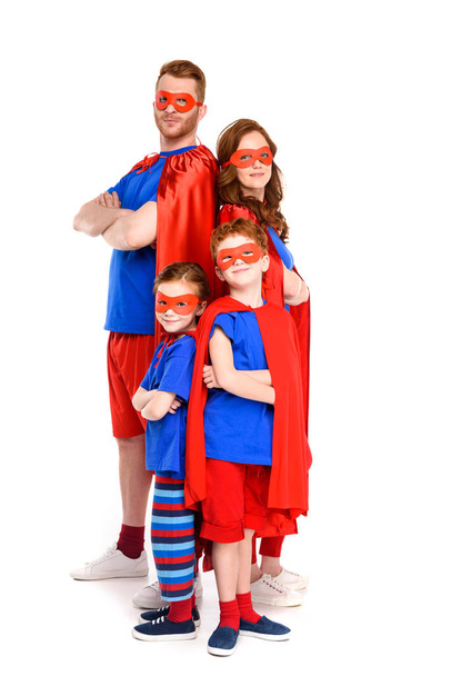 super family in costumes standing with crossed arms and looking at camera isolated on white - Foto, imagen