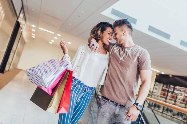 Boldog fiatal pár bevásárló táskák, séta a mall - értékesítés, fogyasztás, és az emberek koncepció  - Fotó, kép