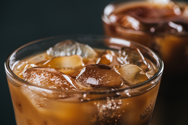 close up view of ice cubes in cold brewed coffee in glass on dark background - Photo, Image