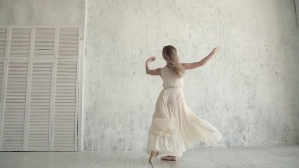 Een gracieuze ballerina in een licht vliegen jurk dansen op spitzen in pointe-schoenen. - Video