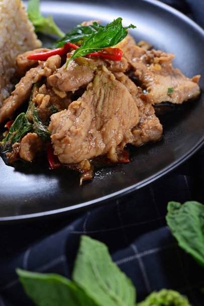 Keverjük sült csirke bazsalikommal és rizs, fekete háttér. thai - Fotó, kép