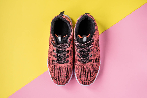 Sneakers on a yellow and pink background top view - Fotó, kép