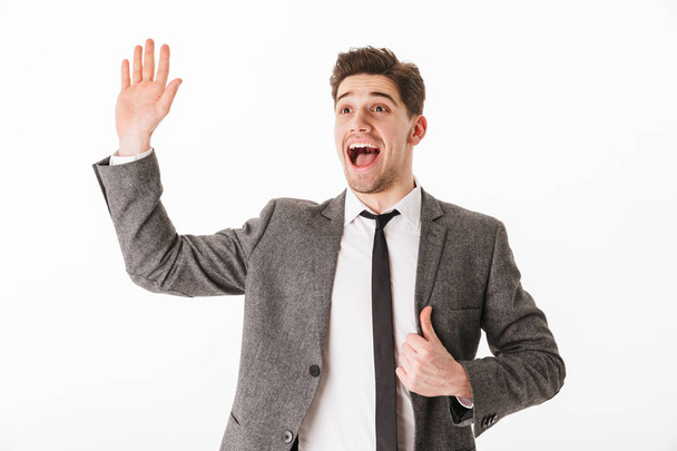 Cheerful business man holding jacket and waving his palm - Foto, afbeelding