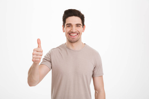 Photo of attractive man 30s having stubble showing thumb up on c - Fotoğraf, Görsel