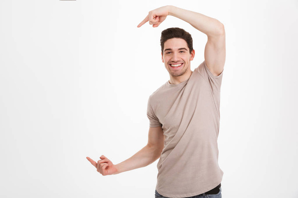 Young happy man 30s wearing beige t-shirt expressing joy when ge - Valokuva, kuva